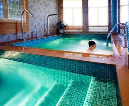 Una persona disfrutando de la piscina con elementos de hidroterapia del hotel.