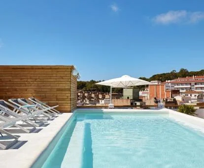 Piscina exterior de hotel con solarium y preciosas vistas a la ciudad.