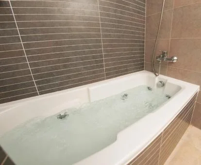 Amplia bañera de hidromasaje privada en el baño de este apartamento.