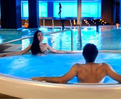Pareja disfrutando de la zona de aguas del spa del hotel.