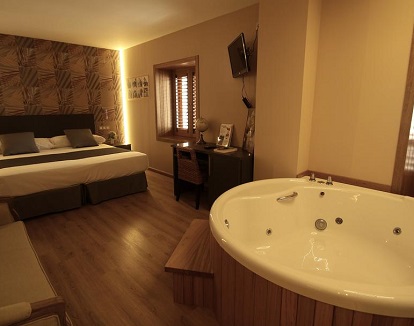 Foto del jacuzzi frente a la cama que se encuentra en la habitación doble superior con bañera de hidromasaje del Hotel De Martin en San Lorenzo del Escorial