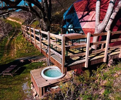 Espectacular domo geodésico sobre los árboles con terraza y jacuzzi exterior.