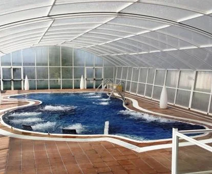 Piscina cubierta con elementos de hidroterapia del spa del hotel.