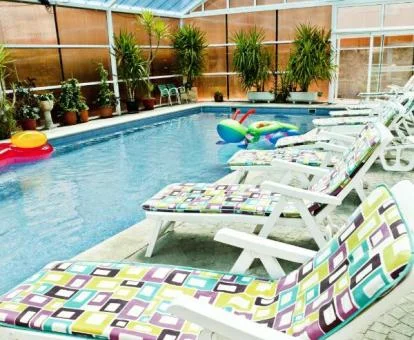 Piscina cubierta con tumbonas de este acogedor hotel rural.