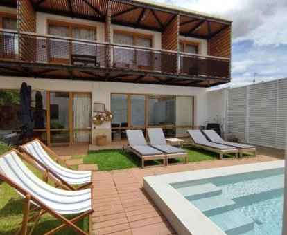 Edificio de este hotel acogedor con zona exterior con mobiliario y piscina.