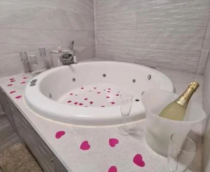 Bañera de hidromasaje circular con decoración romántica de este apartamento deluxe.
