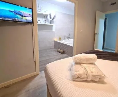 Dormitorio con bañera de hidromasaje privada cerca de la cama de este apartamento independiente.