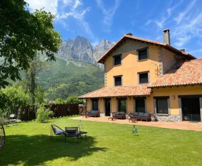 Edificio de este hotel rural con amplios jardines rodeado de montañas.
