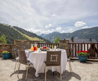 Terraza con comedor exterior y espectaculares vistas a las montañas de este hotel romántico.