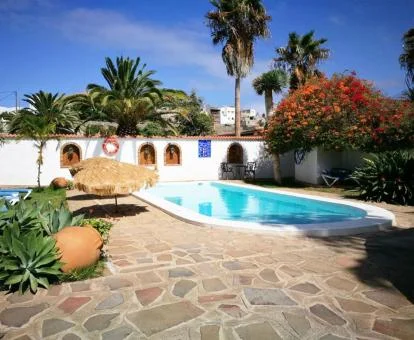 Zona exterior de este hotel rural con piscina y mobiliario.