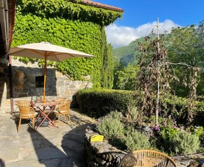 Terraza exterior con mobiliario al aire libre y rodeada de vegetación de este precioso hotel rural.