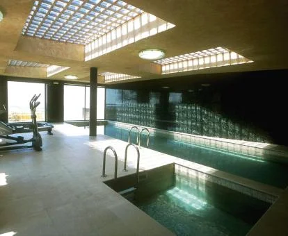 Piscina cubierta con hidroterapia y vistas al exterior del centro de bienestar del hotel.