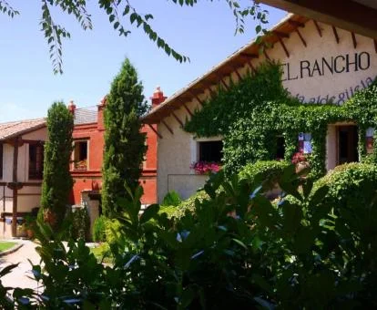 Acogedor hotel rural rodeado de jardines y vegetación.