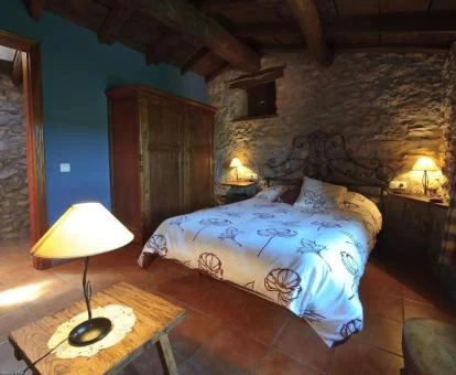 Una de las cómodas habitaciones de estilo tradicional con paredes de piedra.