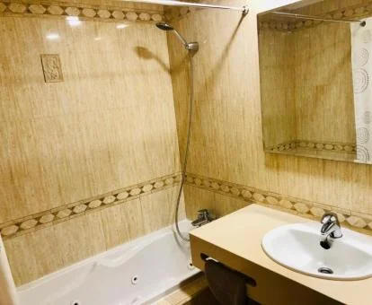 Baño con bañera de hidromasaje privada del apartamento de dos dormitorios con vistas al mar.