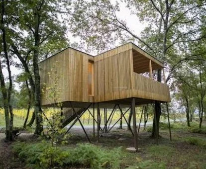 Preciosa cabaña de madera entre árboles con terraza y jacuzzi privado.