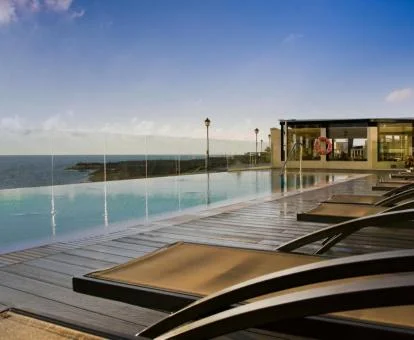 Piscina de borde infinito de este hotel con vistas al mar.