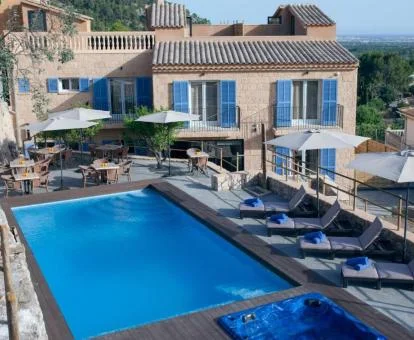 Coqueto hotel boutique con piscina exterior, jacuzzi y mobiliario al aire libre.