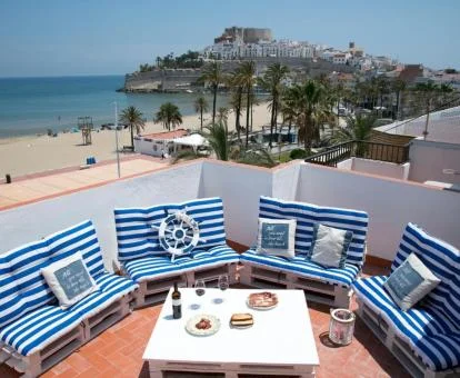 Terraza chill out del establecimiento con mobiliario exterior y vistas al mar.