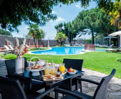 Amplios jardines con mobiliario y piscina de este hotel con encanto.