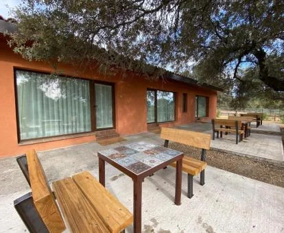 Complejo de apartamentos con mobiliario exterior y naturaleza.