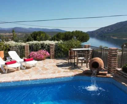 Amplia piscina rodeada de vegetación y con vistas a la naturaleza de este alojamiento.
