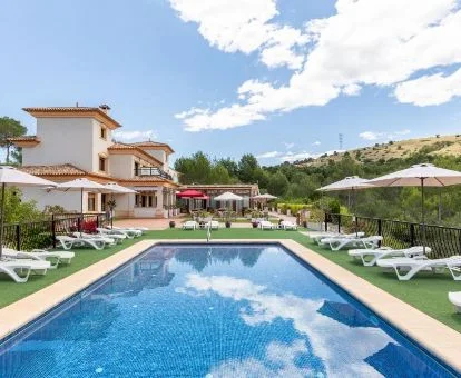 Hermoso edificio de este hotel rural rodeado de campiña con piscina al aire libre.