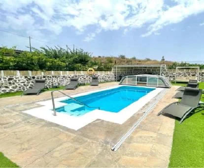 Amplia zona exterior con piscina y tumbonas de este alojamiento.