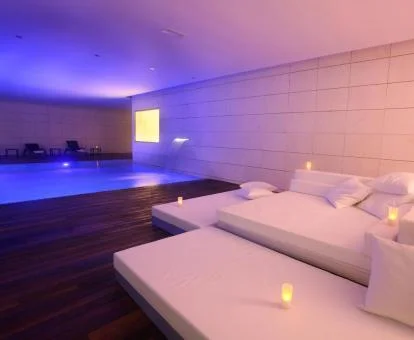 Zona de relajación y piscina cubierta de las instalaciones de bienestar del hotel.
