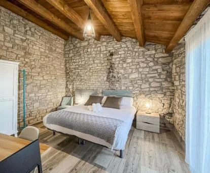 Una de las habitaciones con paredes de piedra a la vista de este coqueto agroturismo.