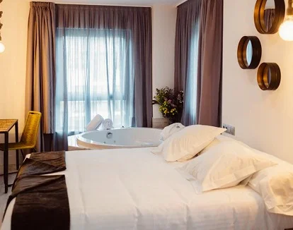 Foto de la habitación doble confort con el jacuzzi junto a la cama para disfrutar de un baño relanjante en un habitación con mucho encanto