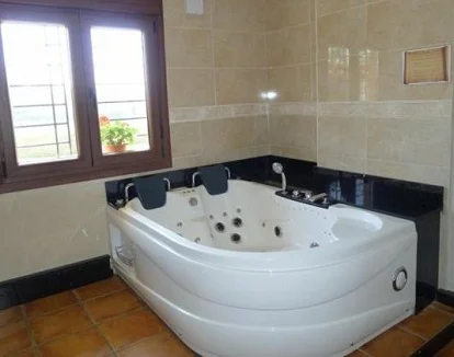 Jacuzzi muy espacioso y grande en un rincón junto a la ventana en la Habitación Doble con bañera de hidromasaje del Hospedaje Villa Pilar en Santillana del Mar