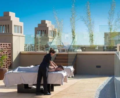 Hombre disfrutando de un masaje en la zona de bienestar al aire libre del hotel.