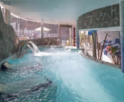Piscina cubierta con elementos de hidroterapia del spa del hotel.