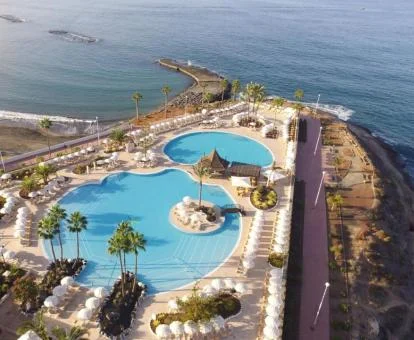 Vista aérea de las zonas exteriores con piscinas de este hotel junto al mar.
