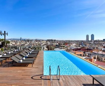 Amplia terraza con piscina de borde infinito y vistas a la ciudad de este hotel con encanto.