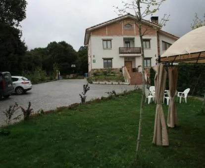 Hotel rural con jardines y mobiliario exterior.