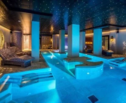 Piscina cubierta con elementos de hidroterapia y zona de relajación.