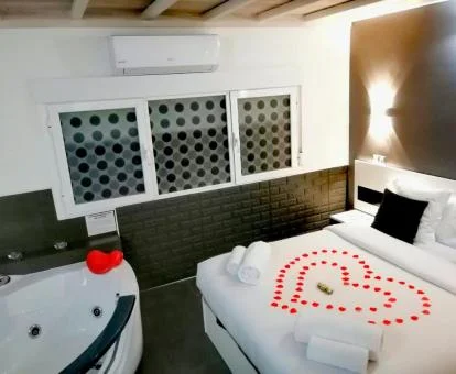 Dormitorio con romántica decoración y jacuzzi junto a la cama de este loft perfecto para parejas.