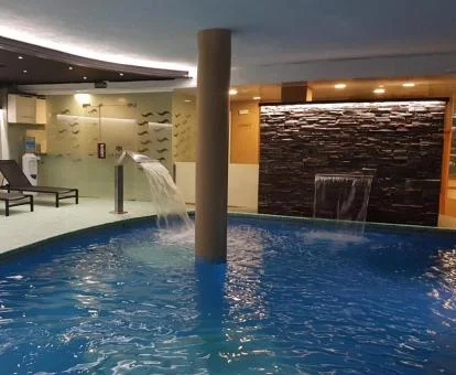 Piscina cubierta con chorros de hidroterapia y zona de relajación del spa del hotel.