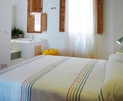 Una de las acogedoras habitaciones con bañera cerca de la cama de este hotel boutique.