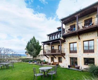 Edificio de este acogedor hotel rural con jardín y mobiliario al aire libre.