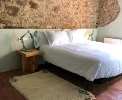 Una de las acogedoras habitaciones dobles con paredes de piedra a la vista del hotel.