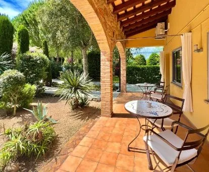 Porche con mobiliario y acceso a los jardines de este bello hotel rural.