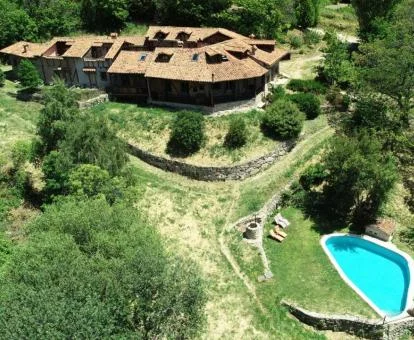 Vista aérea de este hotel con encanto rodeado de vegetación con piscina al aire libre.
