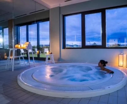 Mujer disfrutando de la zona de bienestar con jacuzzi del hotel.