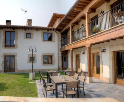 Zona exterior ajardinada con mobiliario de este hotel rural.