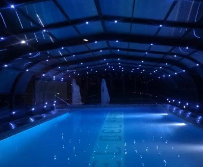 Preciosa piscina cubierta del spa con una acogedora iluminación.