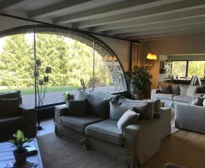Agradable espacio de uso compartido con amplios ventanales y vistas a los jardines del hotel.