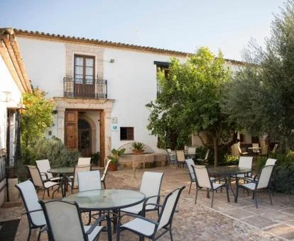 Edificio de este hotel rural con terraza y comedores exteriores.
